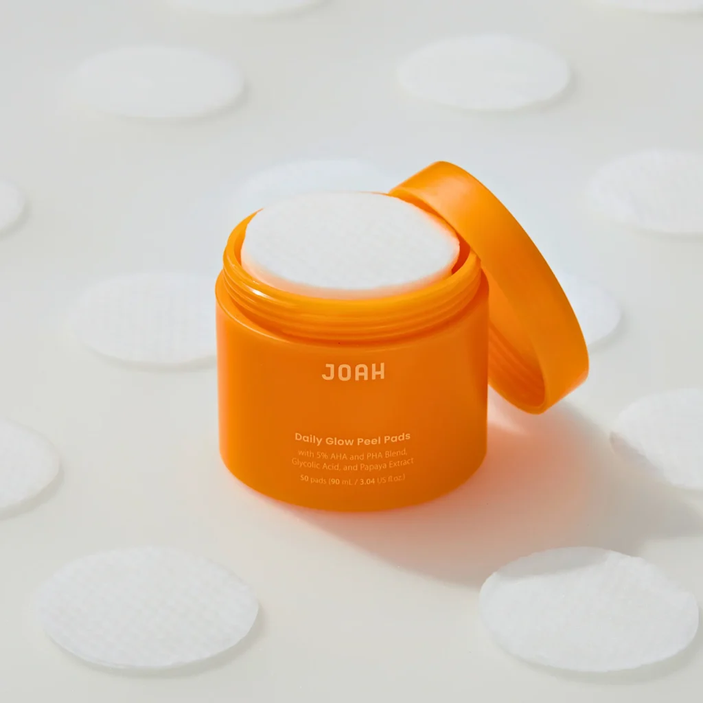 Open JOAH Daily Glow Peel Pads jar with a cotton peel pad